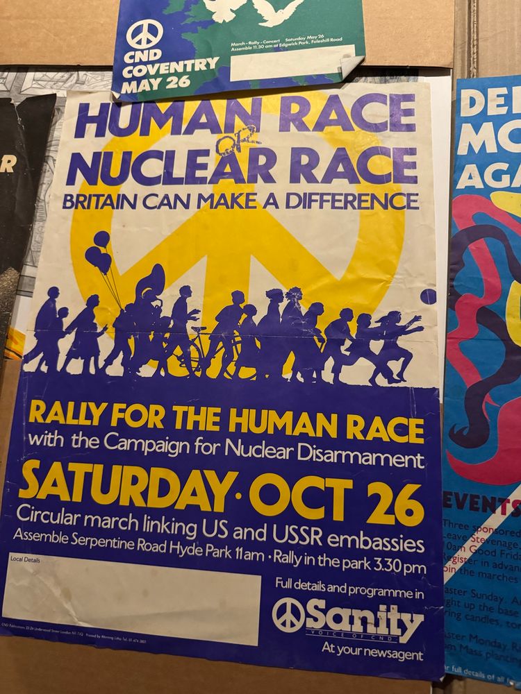 The famous CND logo with the silhouettes of marches and the text “HUMAN RACE NUCLEAR RACE
BRITAIN CAN MAKE A DIFFERENCE
DEI MC AG
RALLY FOR THE HUMAN RACE with the Campaign for Nudear Disarmament
SATURDAY• OCT 26
Circular march linking US and USSR embassies Assemble Serpentine Road Hyde Park 11am • Rally in the park 3.30 pm”