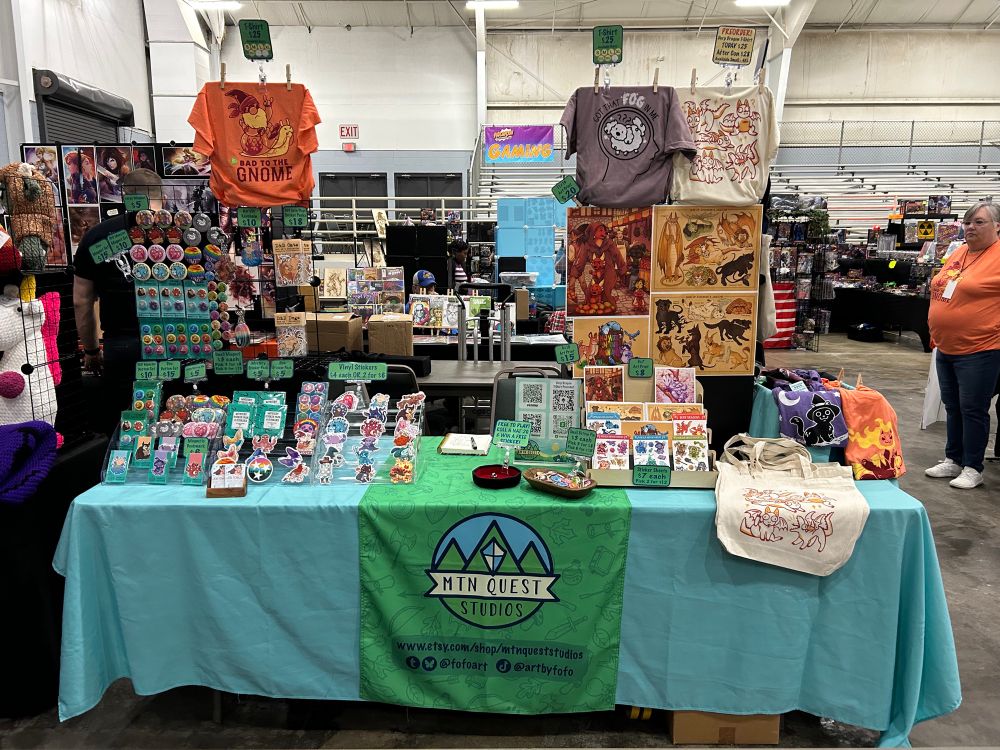 An artist alley set up for Mountain Quest Studios at FarleyCon. 