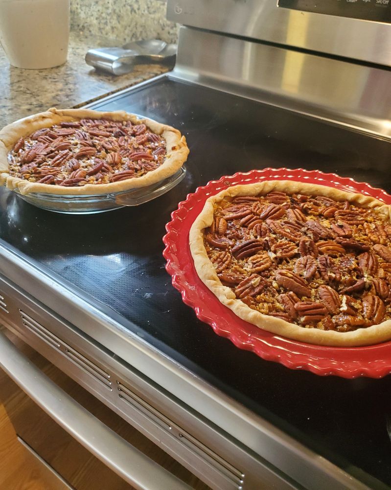 two pecan pies on a stove