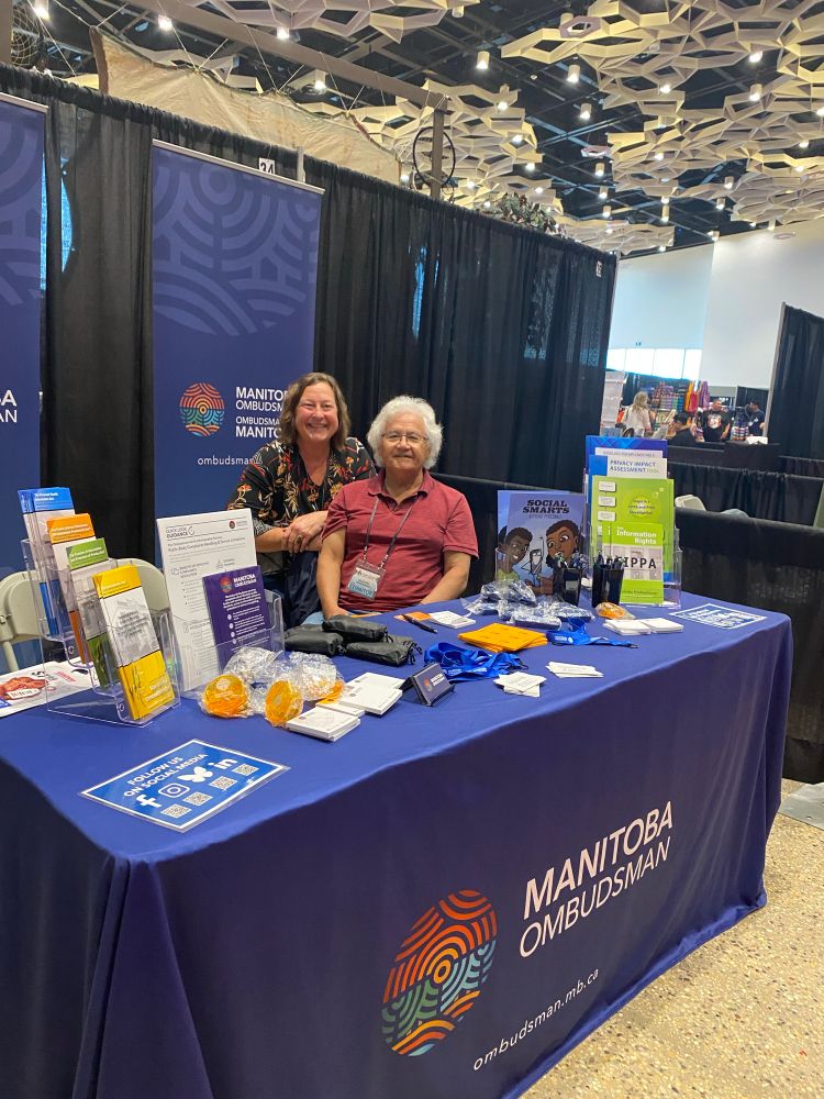 Branded booth with public materials and two staff ready to hand out items
