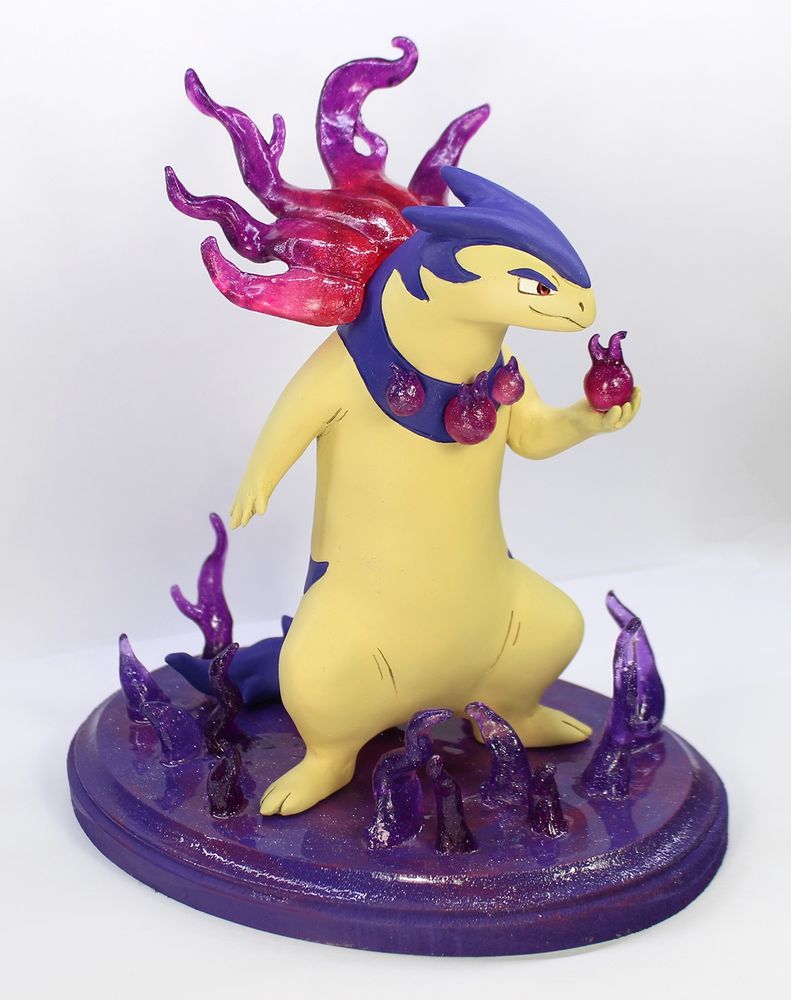 A sculpture of the pokemon hisuian typhlosion.  It has translucent purple flames around its nape and a collar with three smaller flames.  It holds a flame in its hand, looking poised to defend.  It stands atop a base of purple flames.
