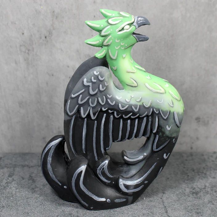A figure of a screaming phoenix, with a gradient of colors reflection the aromantic flag.