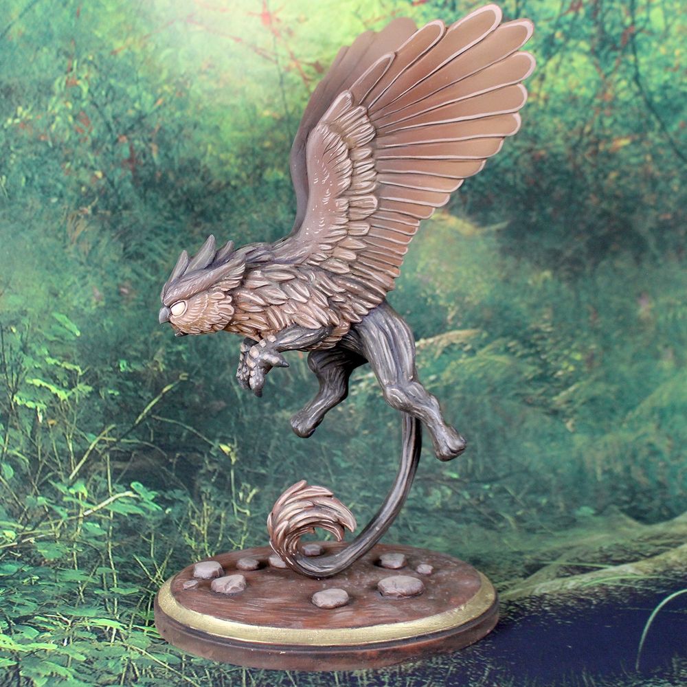 A brown owl gryphon sculpture.  It is flying and being supported by its tail on the base.  It looks fierce.