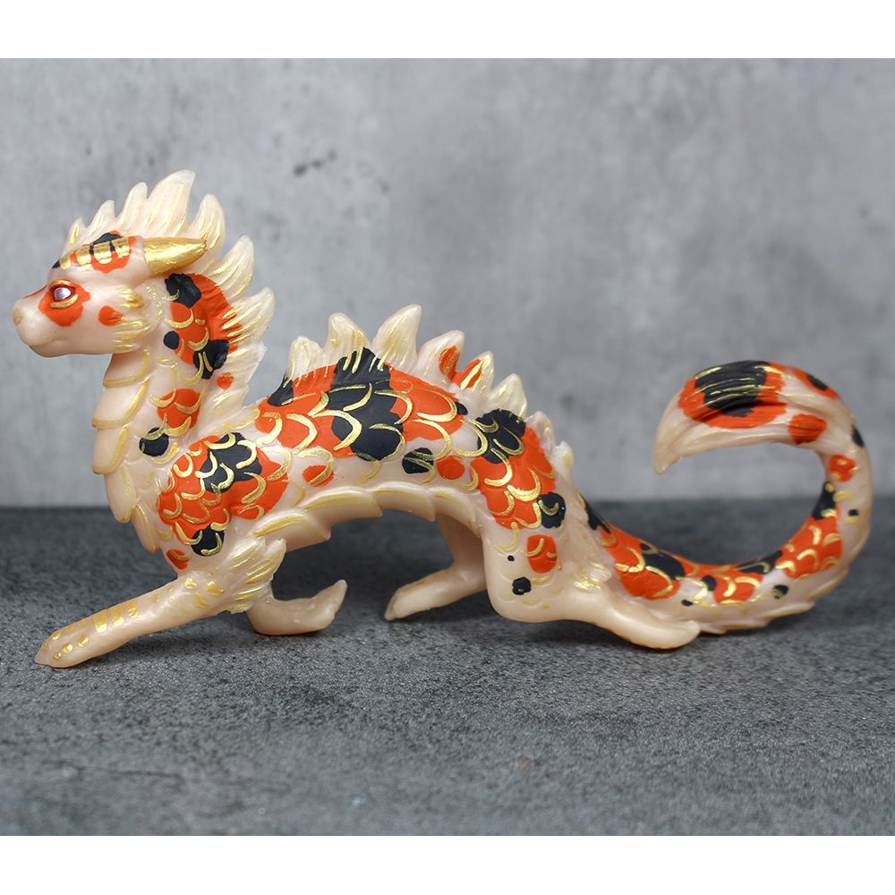 A figure of a white koi colored eastern dragon prancing happily. 