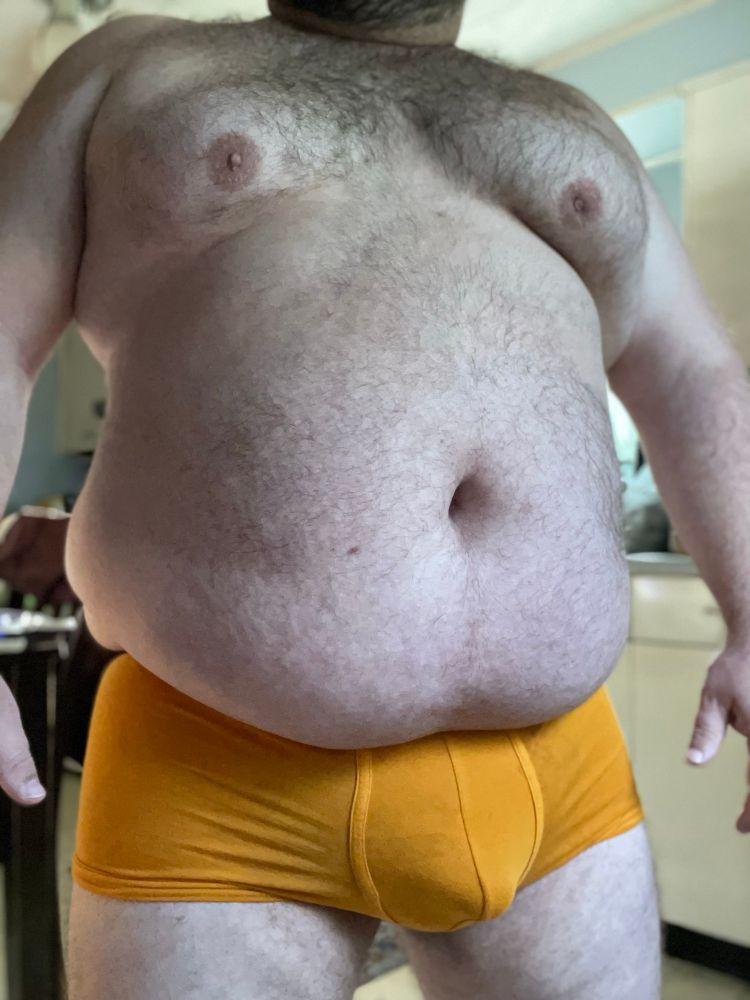 Standing in nothing but orange boxer briefs 