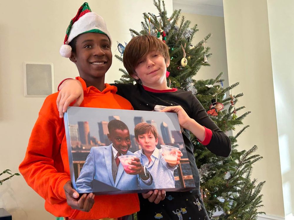 A picture of my son Quincy(13)  and his best friend Maddox (14) holding a picture painted of them celebrating. 
