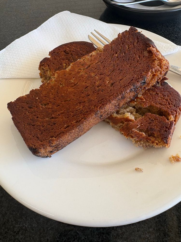 A slice of toasted and buttered banana bread cut into two slices on a white plate.

If you wanted heaven in your mouth, this might be it.