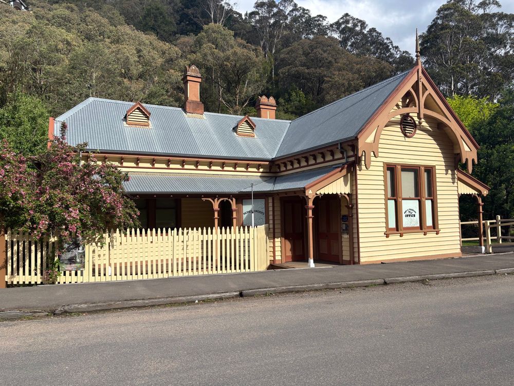 The Post and telegraph office in the township colours of yellow and dried blood red.  It’s L shaped and has a tin roof, single storey with a canopy over the entrance 