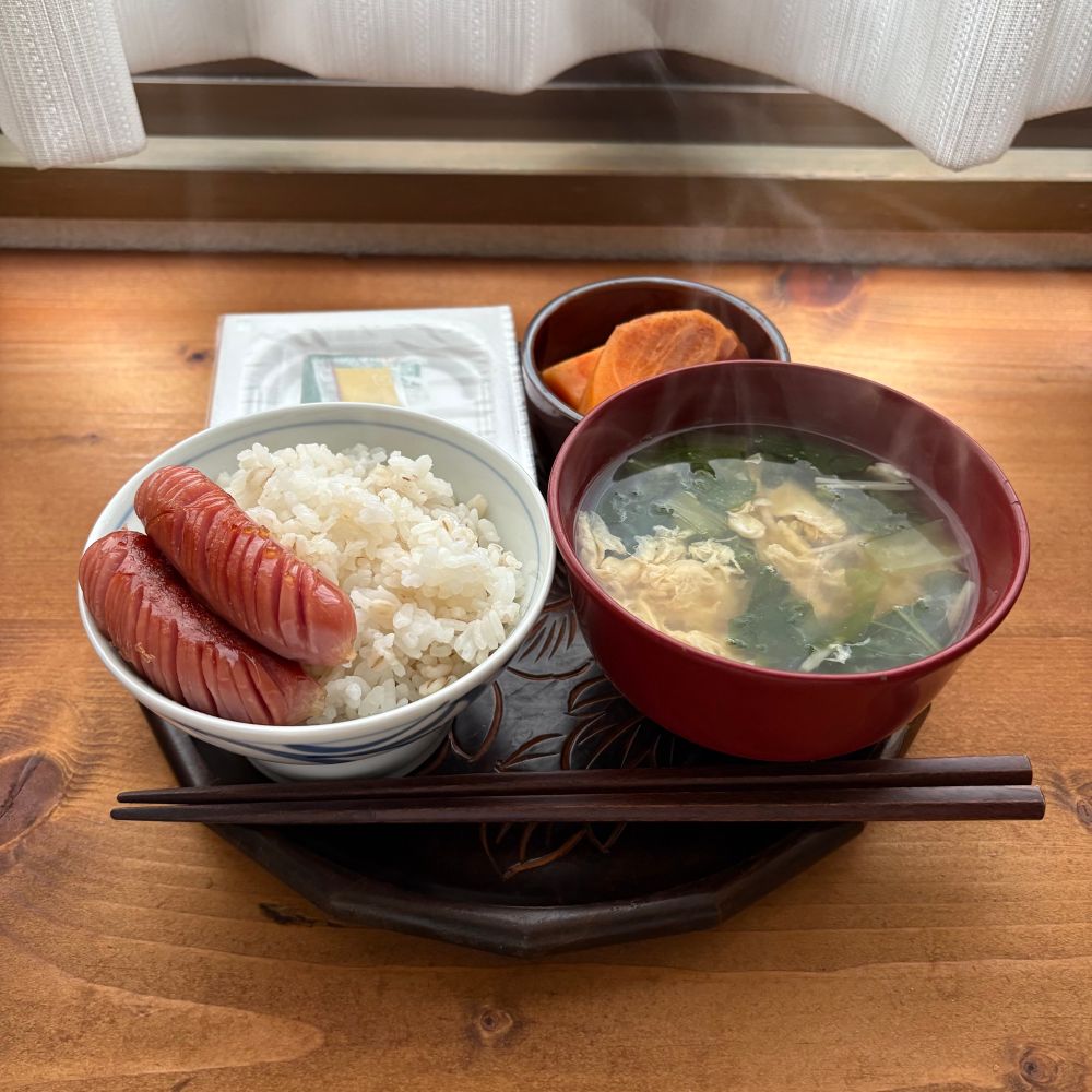 納豆、富有柿、ウィンナー、ご飯、卵、小松菜、えのきの味噌汁