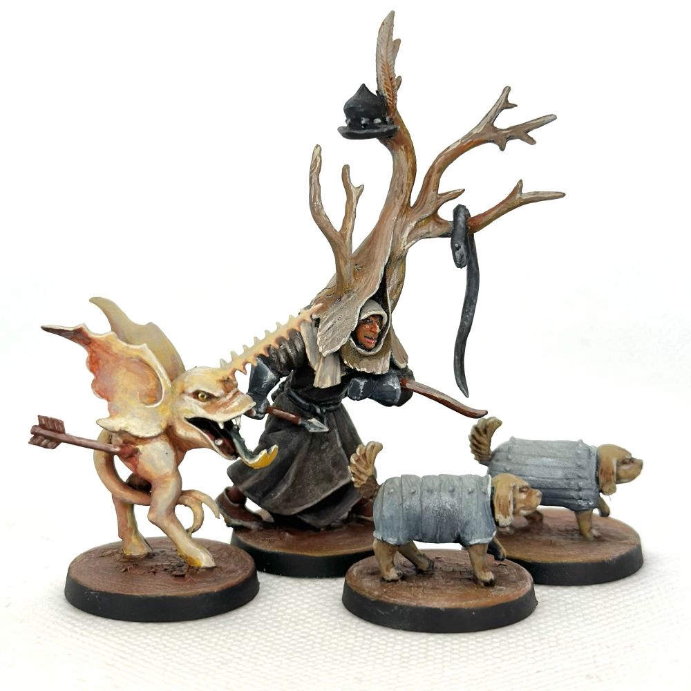 A set of miniature depicting two small armored dogs, a man wearing a tree on his head, and a creature that appears to be a hybrid between a unicorn and a fish