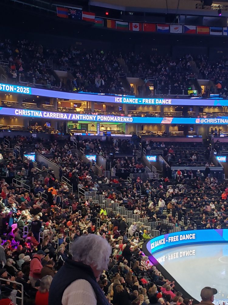 Shot of the audience during the free dance with Christina Carreira and Anthony Ponomarenko's names on the banners as they were being introduced. 