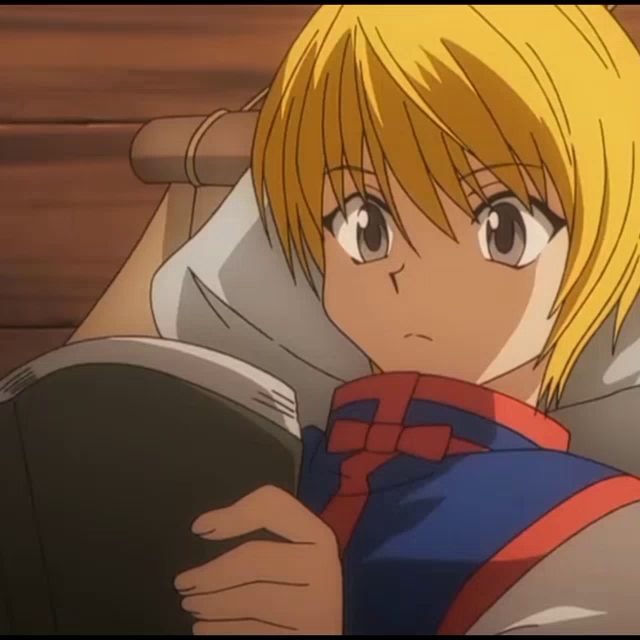 a yellow haired anime character laying on a bed holding a book