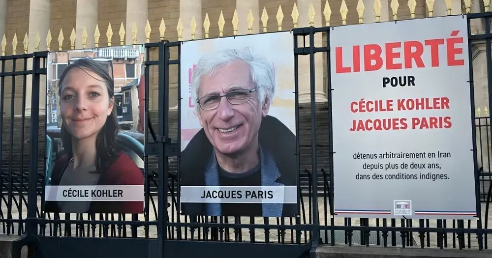 The displayed portraits of French nationals Cécile Kohler and Jacques Paris, held hostage in Iran since May 7, 2022, outside the Palais Bourbon, France's National Assembly. 