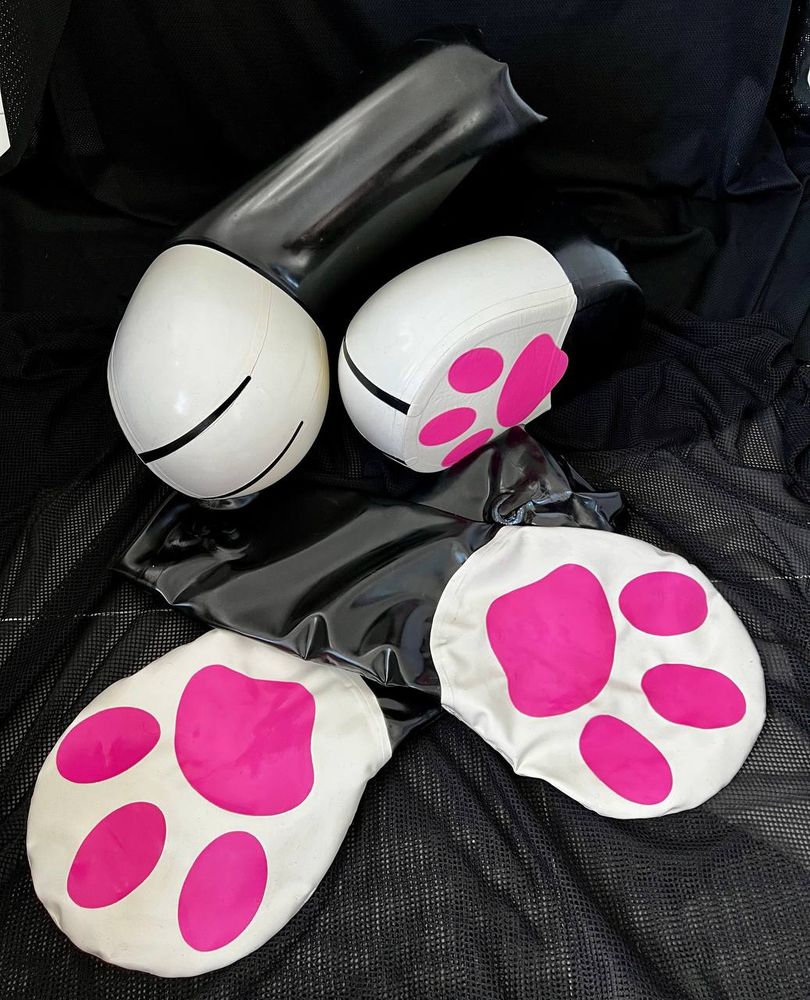 Photo of Inflated rubber paws against a black backdrop.