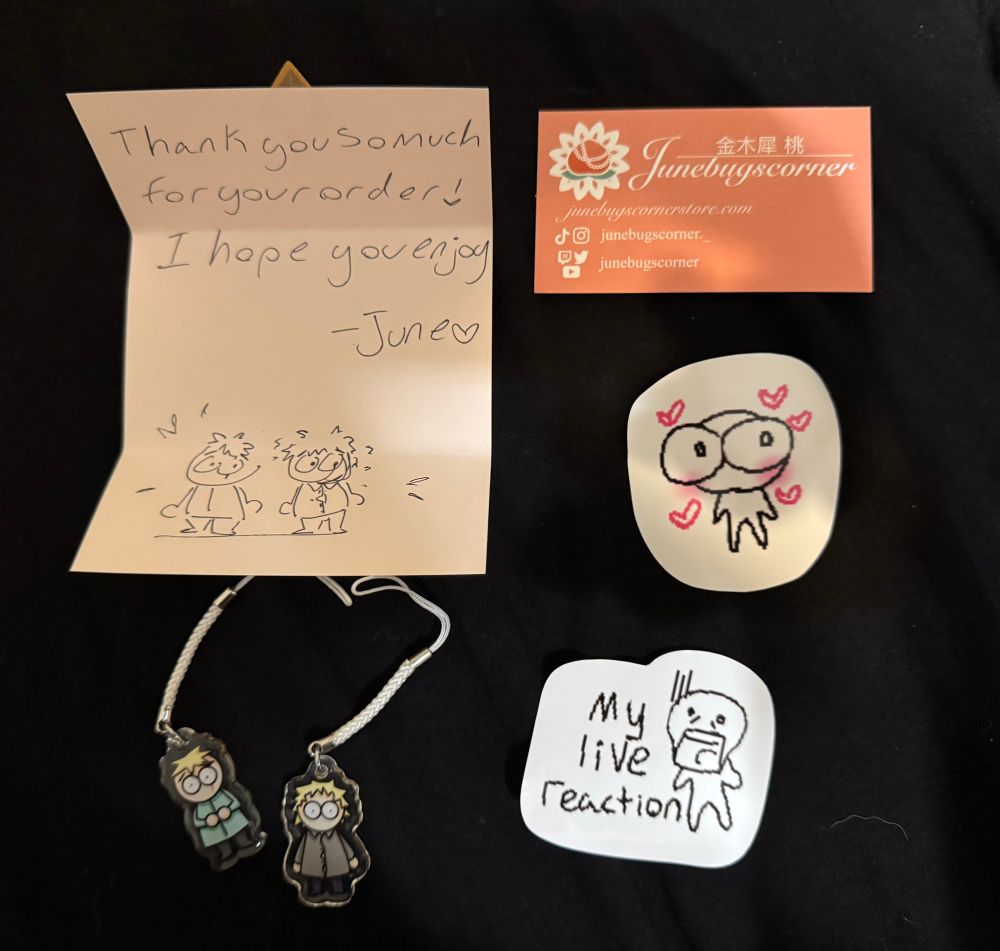 a note reading “Thank you so much for your order! I hope you enjoy -June <3
a business card reading “Junebugscorner juncbugscornerstore.com
junebugscorner._
junebugscorner”

two stickers and two phone charms of butters and tweek from south park