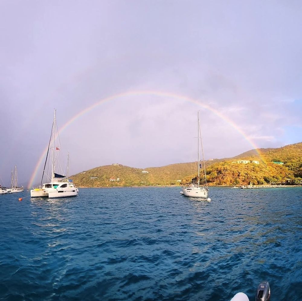 Sailboats with full rainbow in the background at Marina Cay, British Virgin Islands.