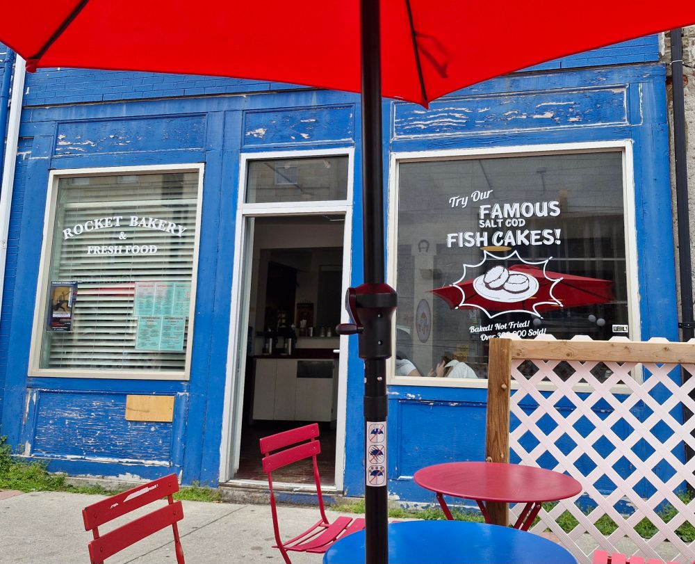A bakery window invites you to try their famous Salt fish cakes