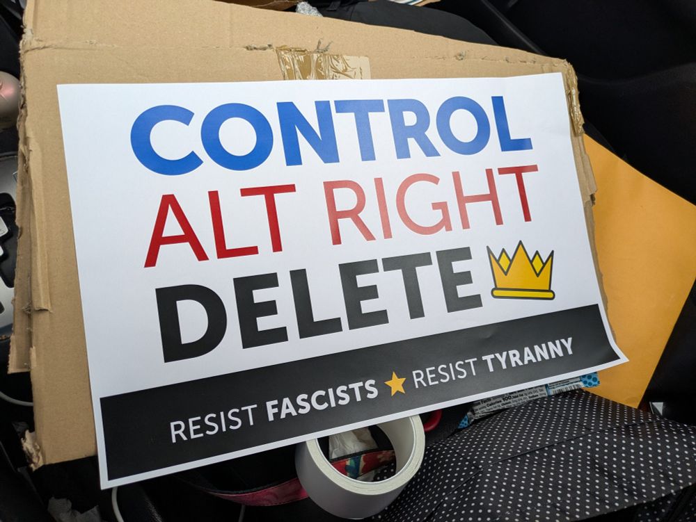 White sign with big lettering "CONTROL. ALT RIGHT. DELETE" and smaller lettering below "RESIST FASCISTS. RESIST TYRANNY"