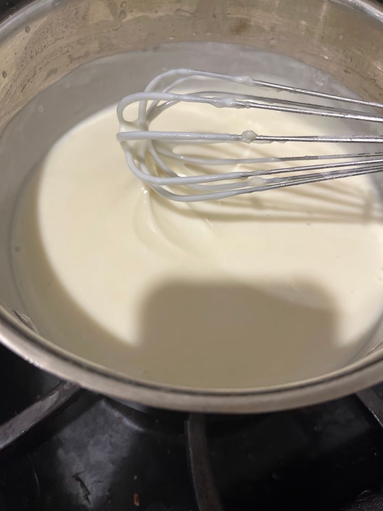 Gorgeous silky white bechamel clinging to metal whisk 