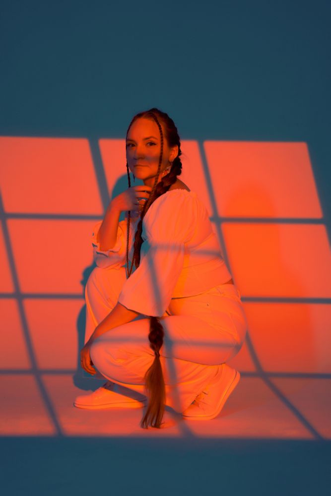 Personal photo full body shot in orange color, sitting with bended knees