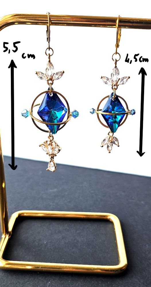a pair of golden earrings looking like aetherytes with blue crystals and little white crystals inspired from the game final fantasy 14

One is bigger than the other one, it's 5.5cm while the others is 4.5 cm