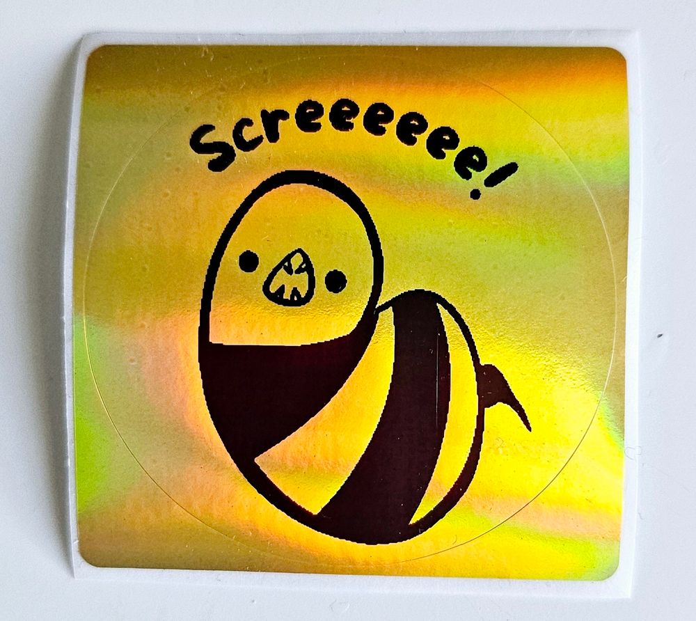 À gold sticker with a ronka snake screaming "screeeee! "