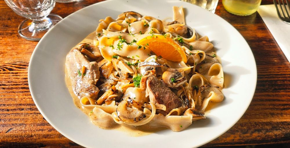 A plate of chestnut pasta with cream, mushrooms and onions 