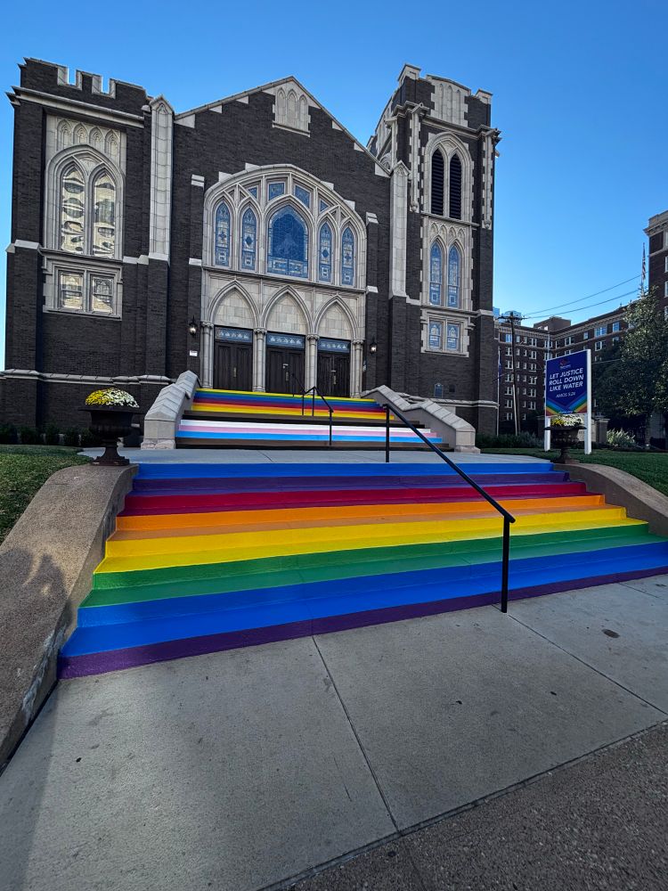 Rainbow stair steps at a church.  The top stair set is painted the colors of the lgbtq pride flag.  The bottom stair set is painted the colors of the rainbow flag. 