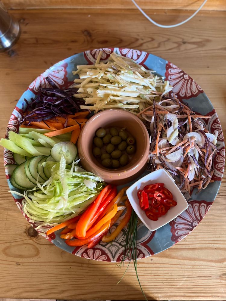 Various salads on a large melamine serving dish with a Portuguese tile design 