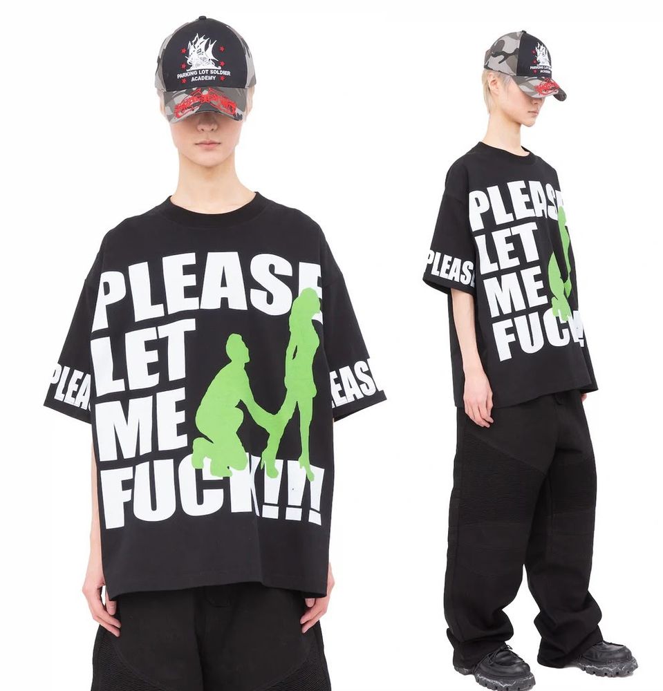 White guy wearing a PLEASE LET ME FUCK shirt with baggy, black pants, and a baseball cap with the brim pulled down over his eyes