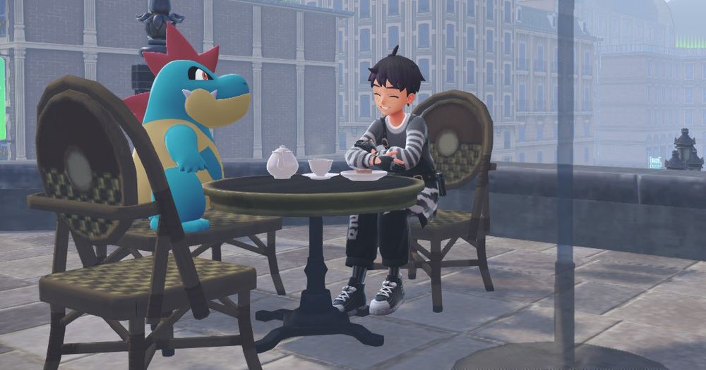 A trainer wearing black and white overalls, shoes, and shirt with purple and black hair smiles with his eyes closed at a Croconaw over tea.