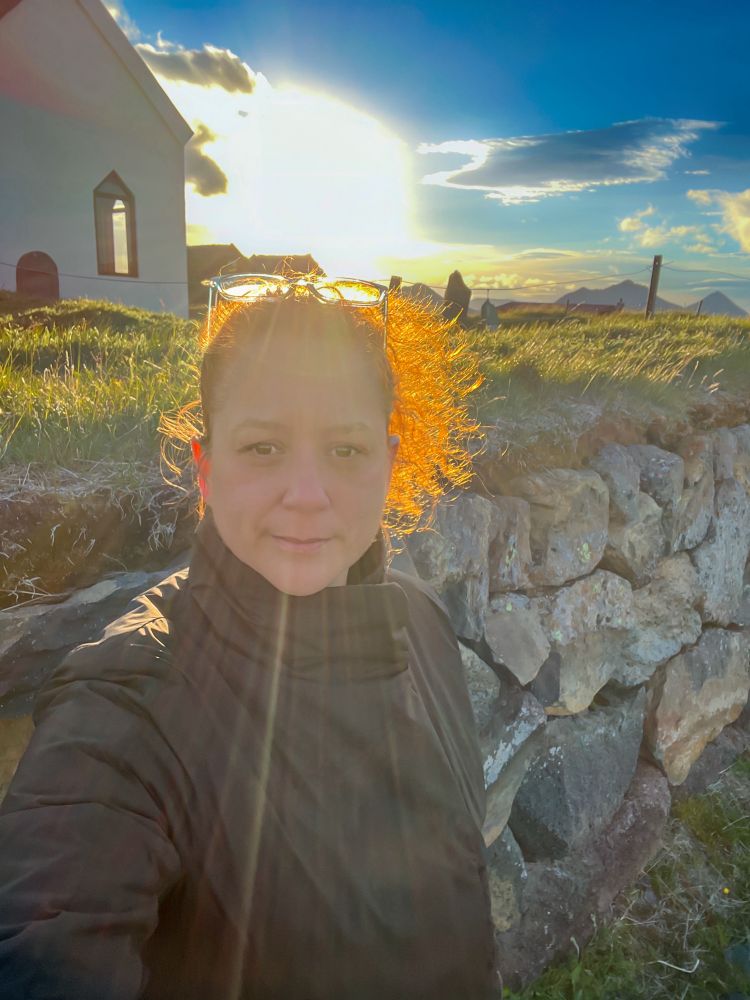 A brightly backlit selfie in Iceland with my hair flying around 