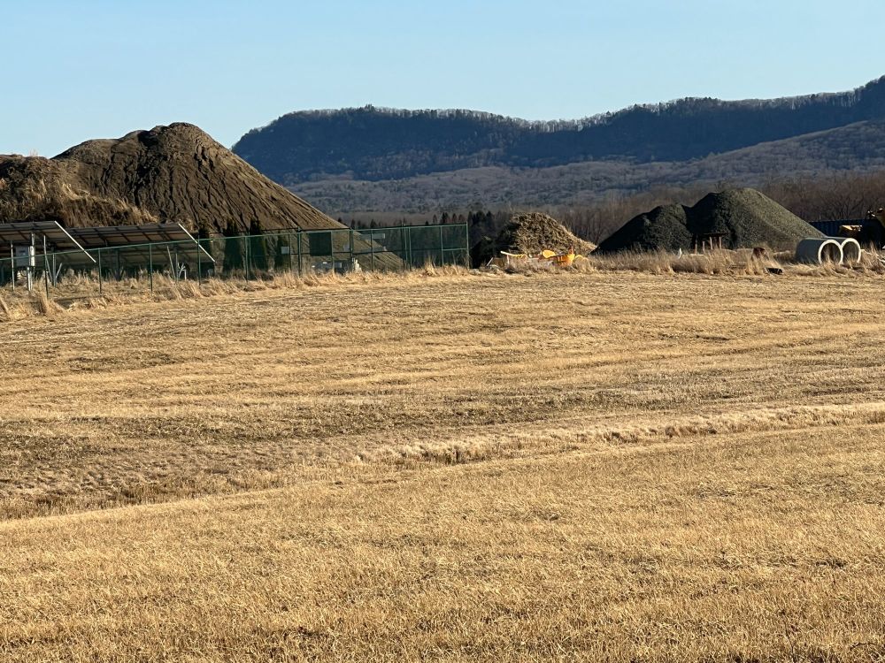 View of the Holyoke range behind some very large dirt heaps along the rail trail, Hadley , Massachusetts