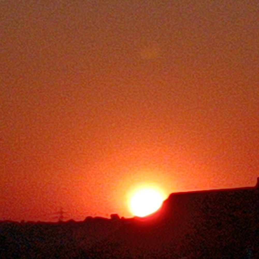 Image of sunrise behind roof
