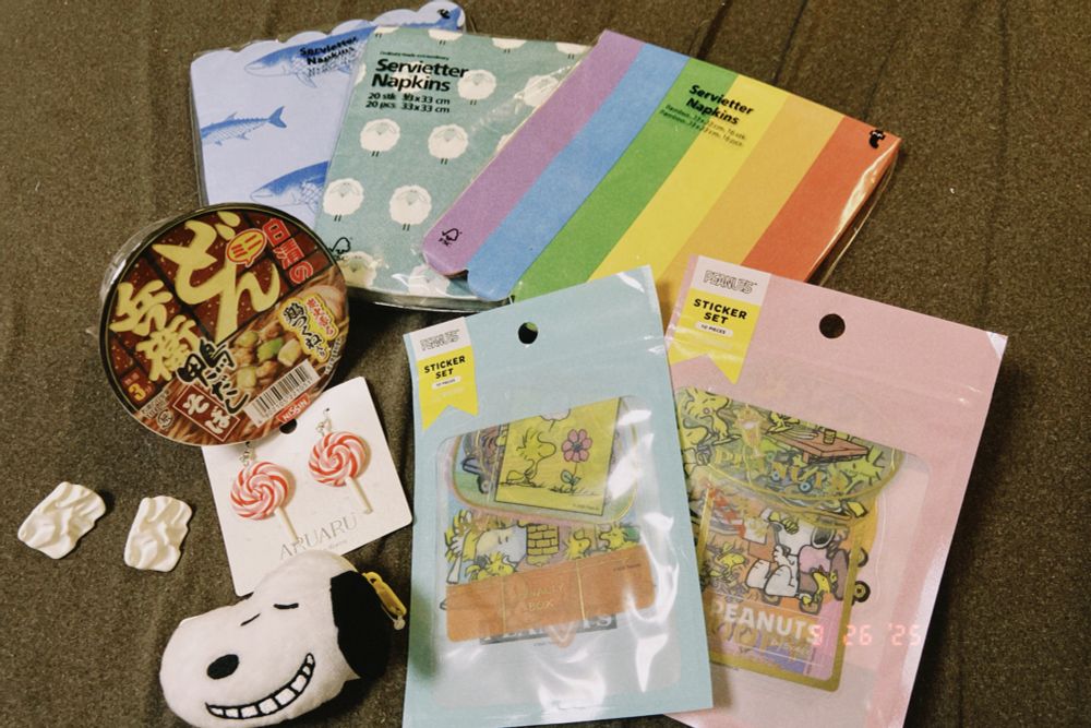 フライングタイガーのペーパーナプキン、ミニどん兵衛、スヌーピーのステッカー、スヌーピーのポーチ、キャンディのピアス、無造作な立体のピアス。
