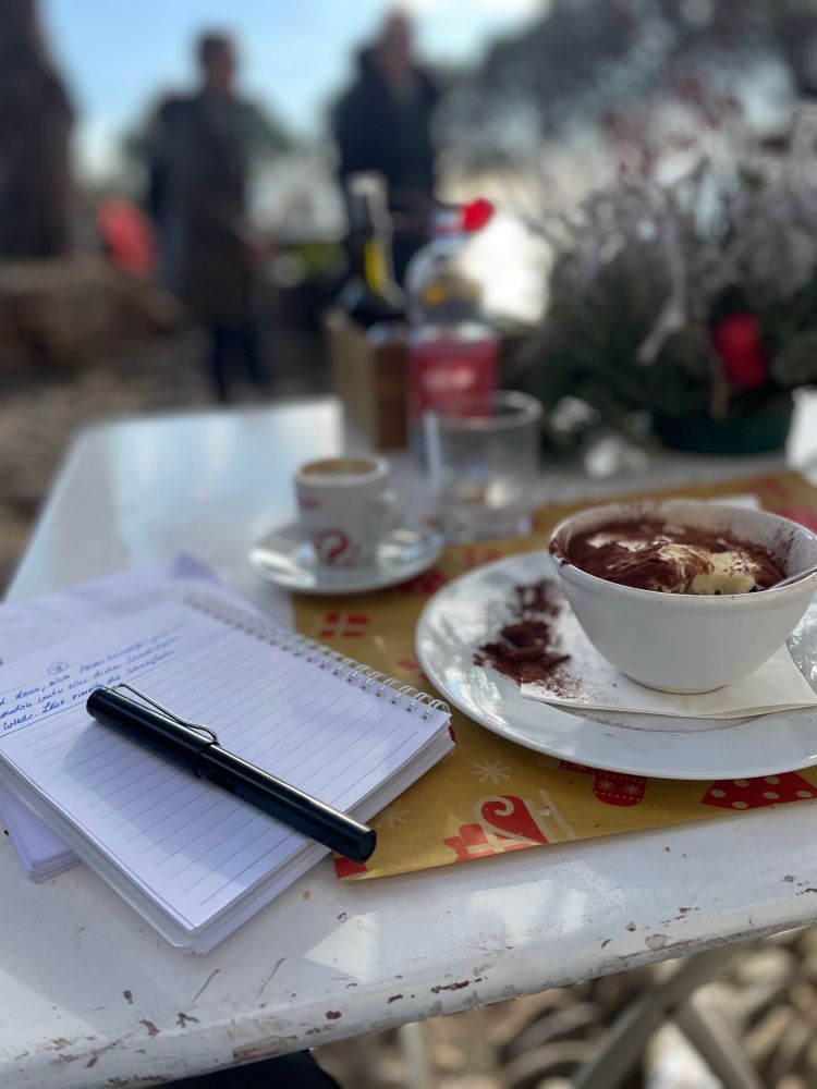 Photo of tiramisu, espresso and my writing notebook. Sunny scene in italy