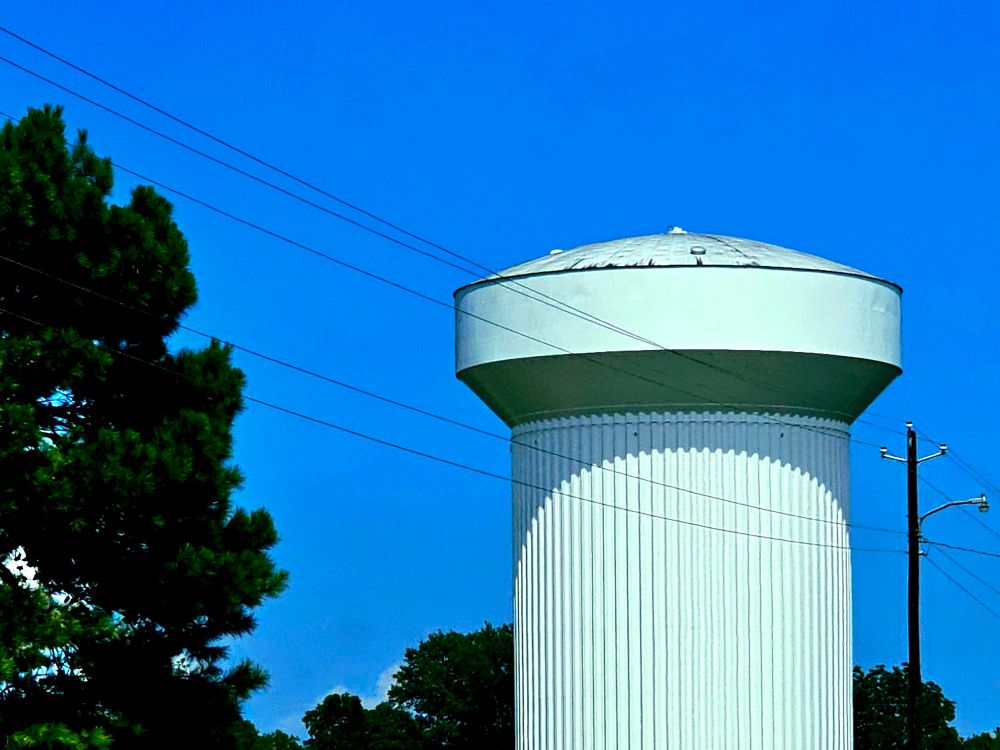 A big, slightly uncanny water tower. Its weird shape along with the almost straight-on lighting makes it seem out-of-place with its natural surroundings.