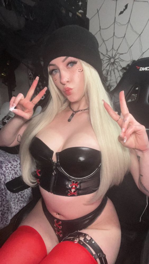 Marley Maxwell in a bling wig and black and red latex lingerie throwing up peace signs