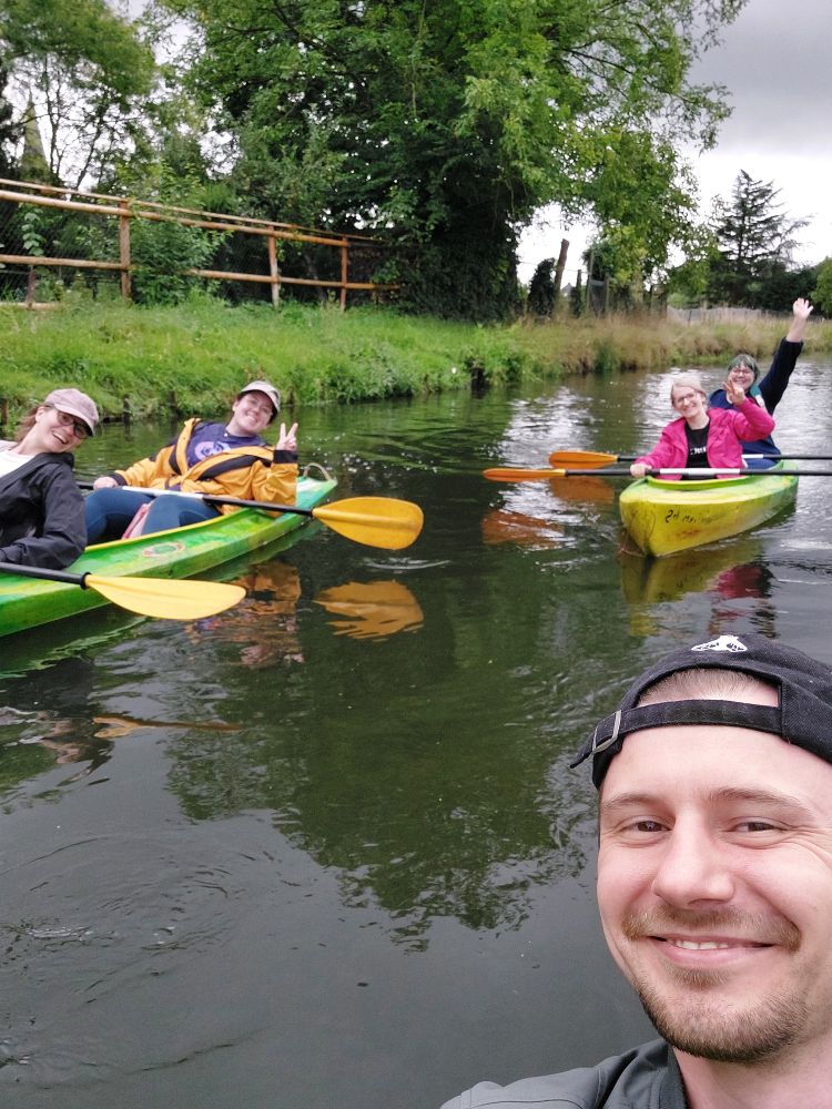 Grinseselfie aus den Kayak, im Hintergrund zwei weitere Kayaks mit vier Leuten