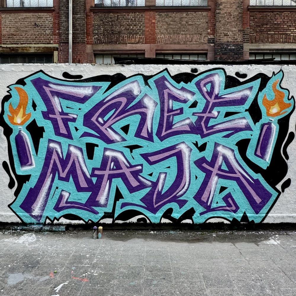 Graffiti: FREE MAJA, daneben zwei Molotovcocktails