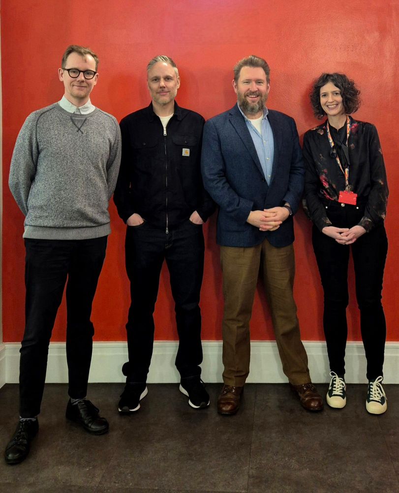 Michael Taster, Jon Sutton, Chris Waiting, Liz Stokoe lined up against a red wall