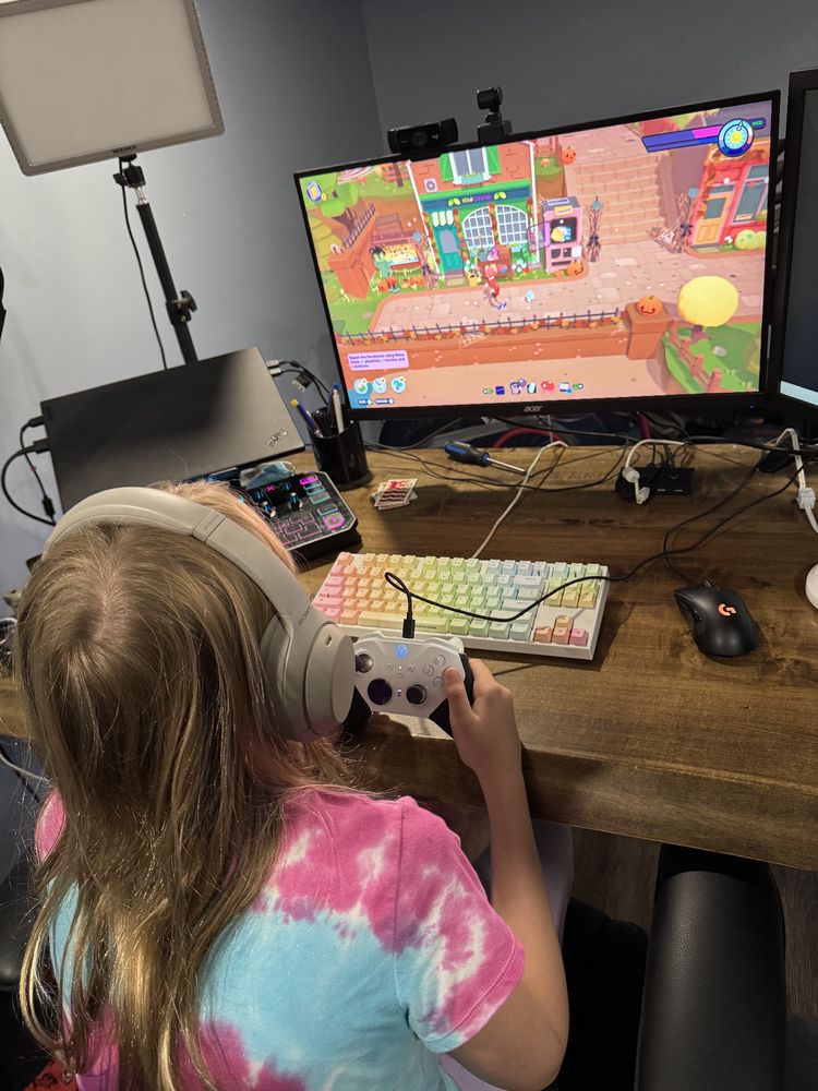 A photo over the shoulder of my eldest daughter on my computer playing Ooblets