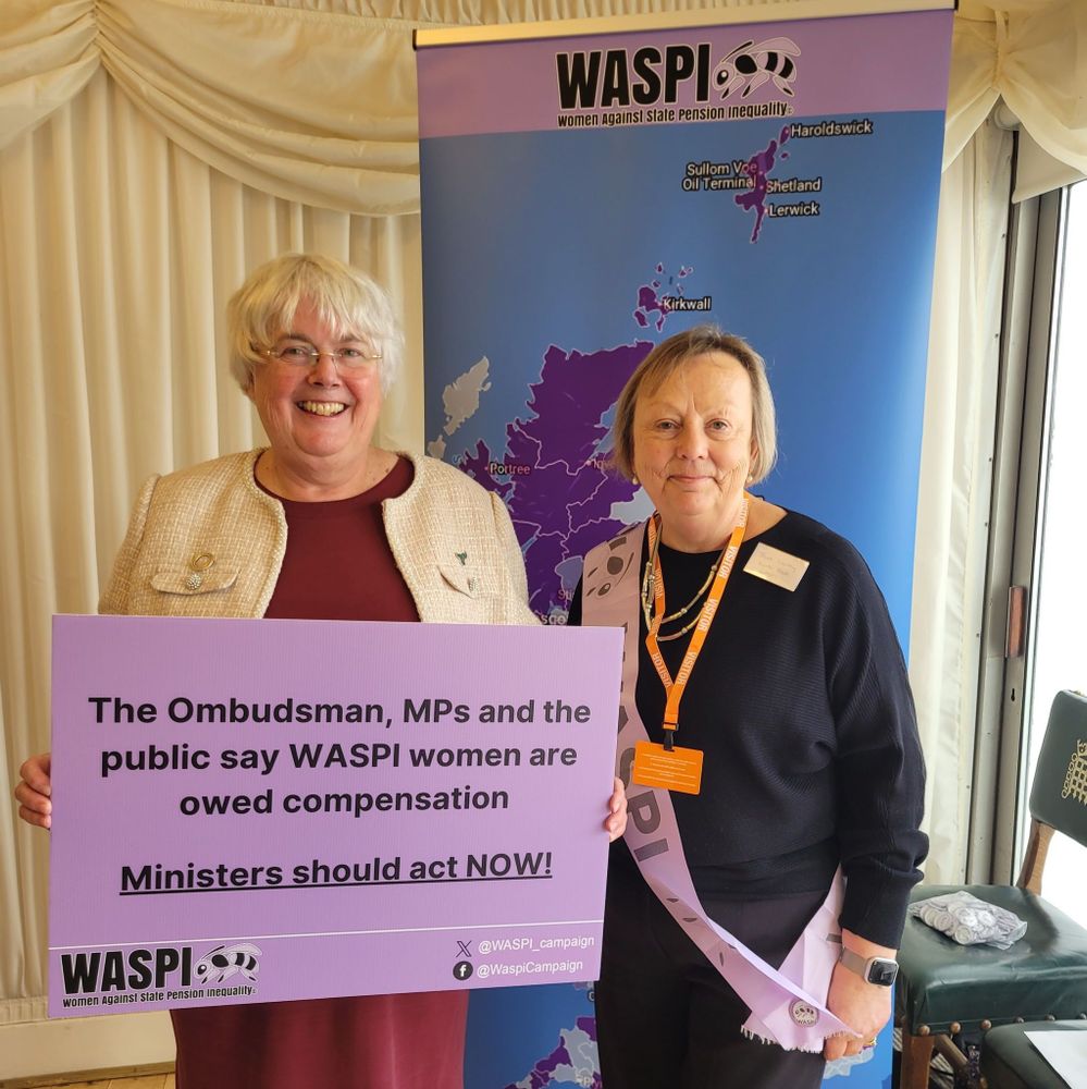 Charlotte Cane with WASPI campaigner, holding a placard saying 'The Ombudsman, MPs and the public say WASPO women are owed compensation. Ministers should act NOW'. 