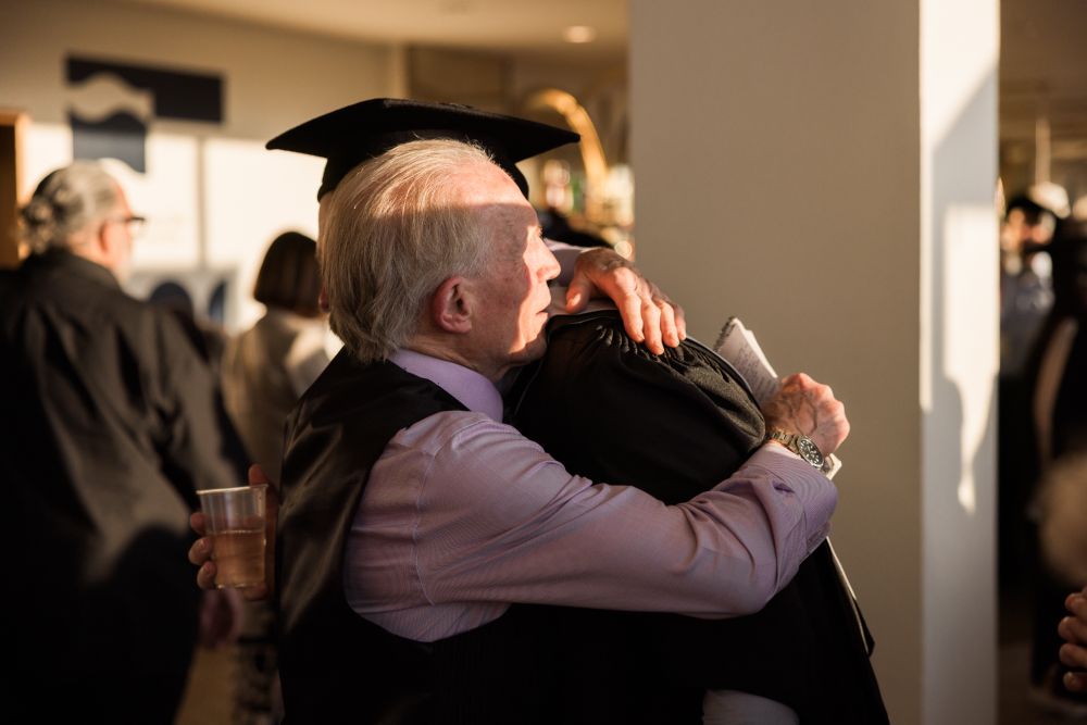 A graduate hugging their guest