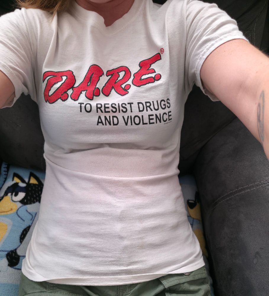 White shirt on a woman with bright red all caps D.A.R.E. 
The text switches to smaller caps saying "to resist drugs and violence"