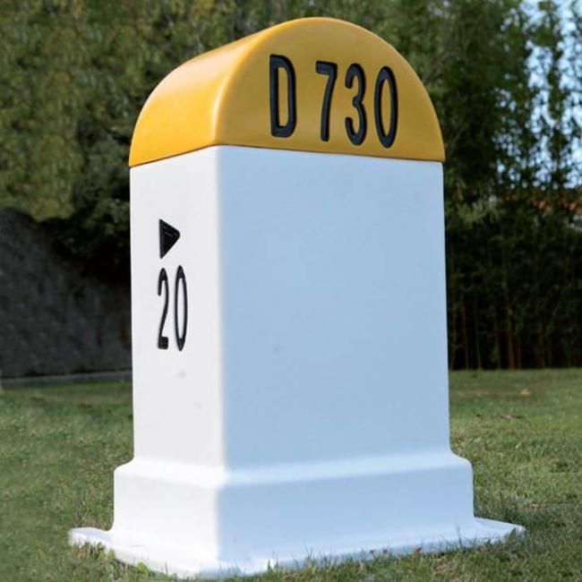 Avant : une borne kilométrique blanche et jaune de route départementale française.