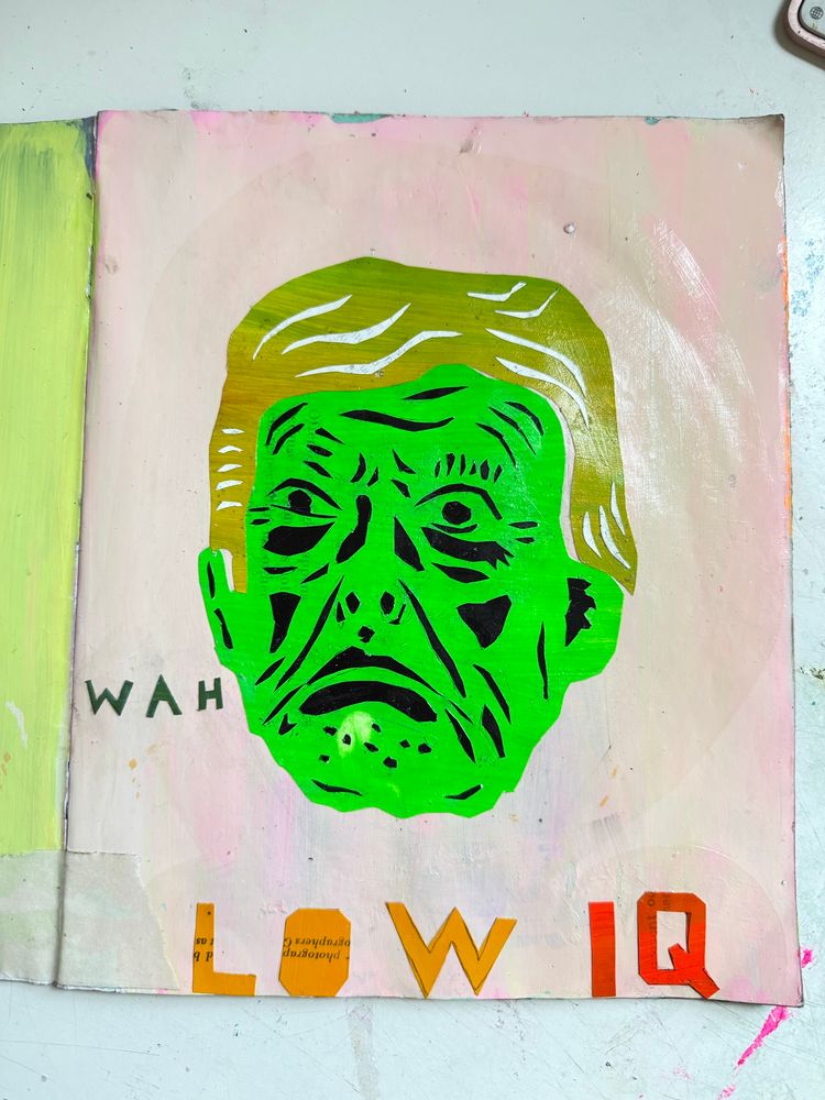 A picture of trumps floating head. The background is pale pink. His head is fluorescent green with his features cut out if black paper. His hair is puke green green with highlight cut from white paper. He looks like a monster. The word WAH is placed to the left of his mouth. At the bottom of the page is says LOW IQ made from cut paper. 
