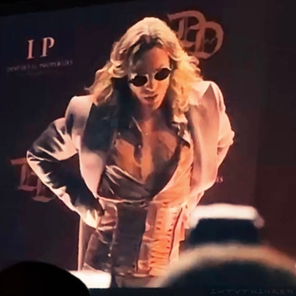 Image of Sam Reid as Lestat de Lioncourt in AMC's Interview with the Vampire Season 3 trailer. He's wearing a blush pink suit, matching shirt and corset with round black sunglasses