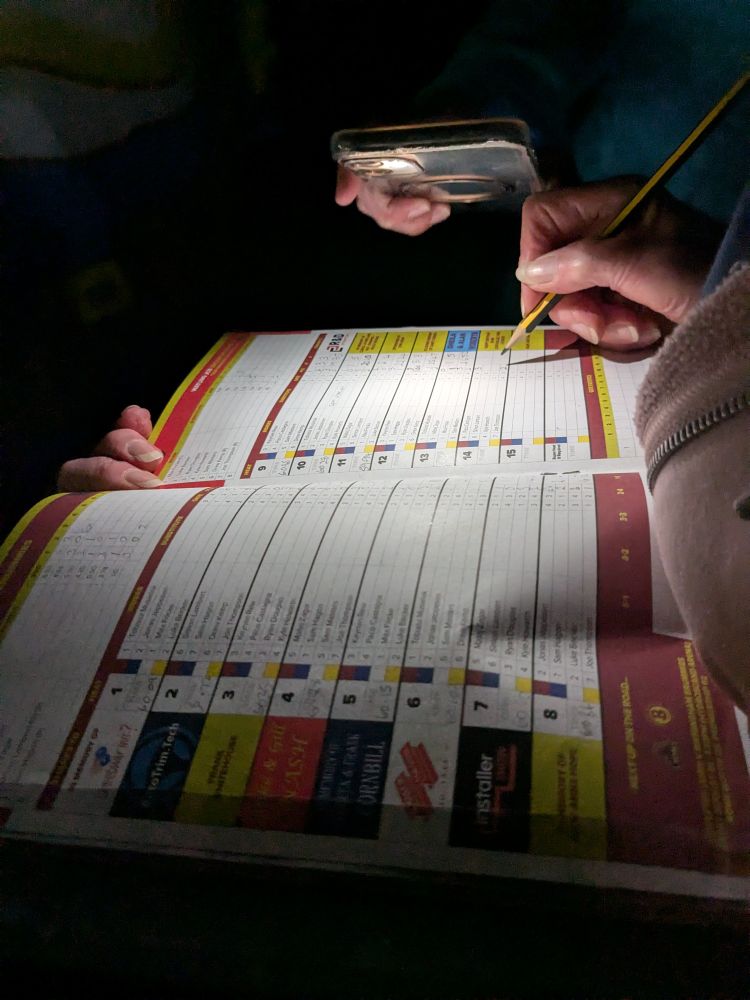 My mam marking scores in the programme by torchlight.