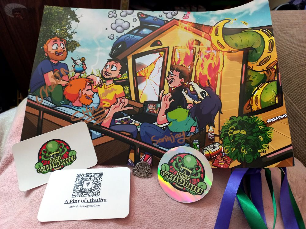 a print of Tony's art, signed by the people depicted in it, members of the A Pint of Cthulhu podcast. propped on it, the podcast's socials in a couple of business cards, a holographic sticker, and a metal pin with their logo on it. 